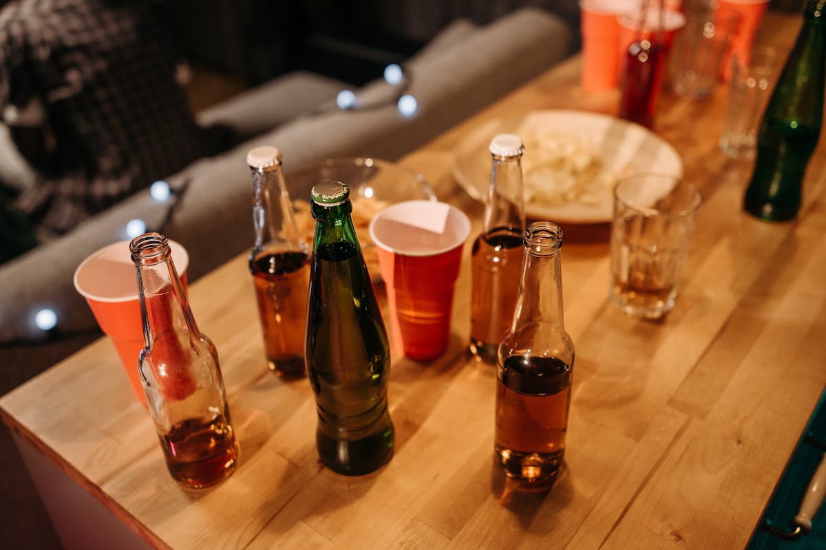 Beer Bottles and Plastic Cups on Wooden Table
