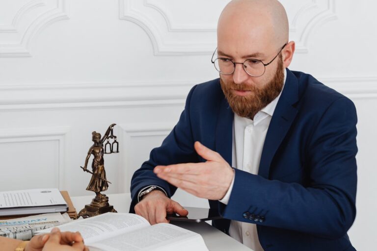 A Man in Blue Suit Sitting Beside the White Desk