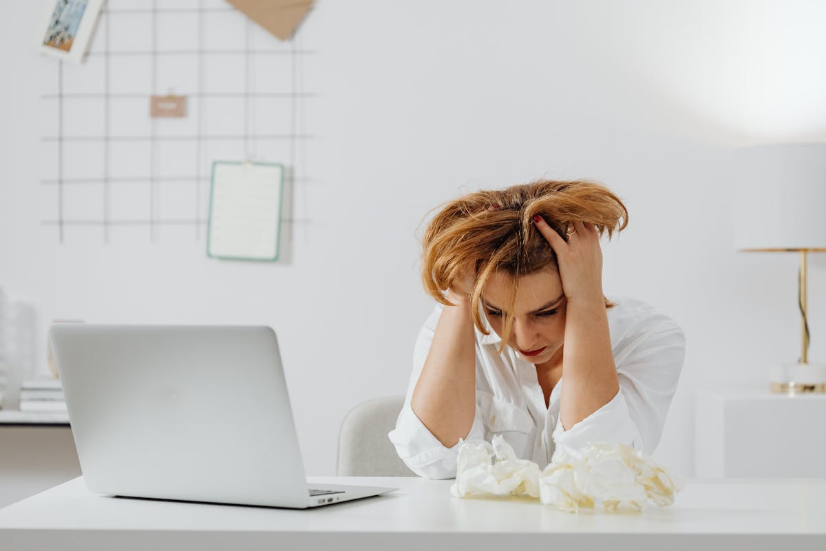 A Woman in White Long Sleeves Looking Stressed
