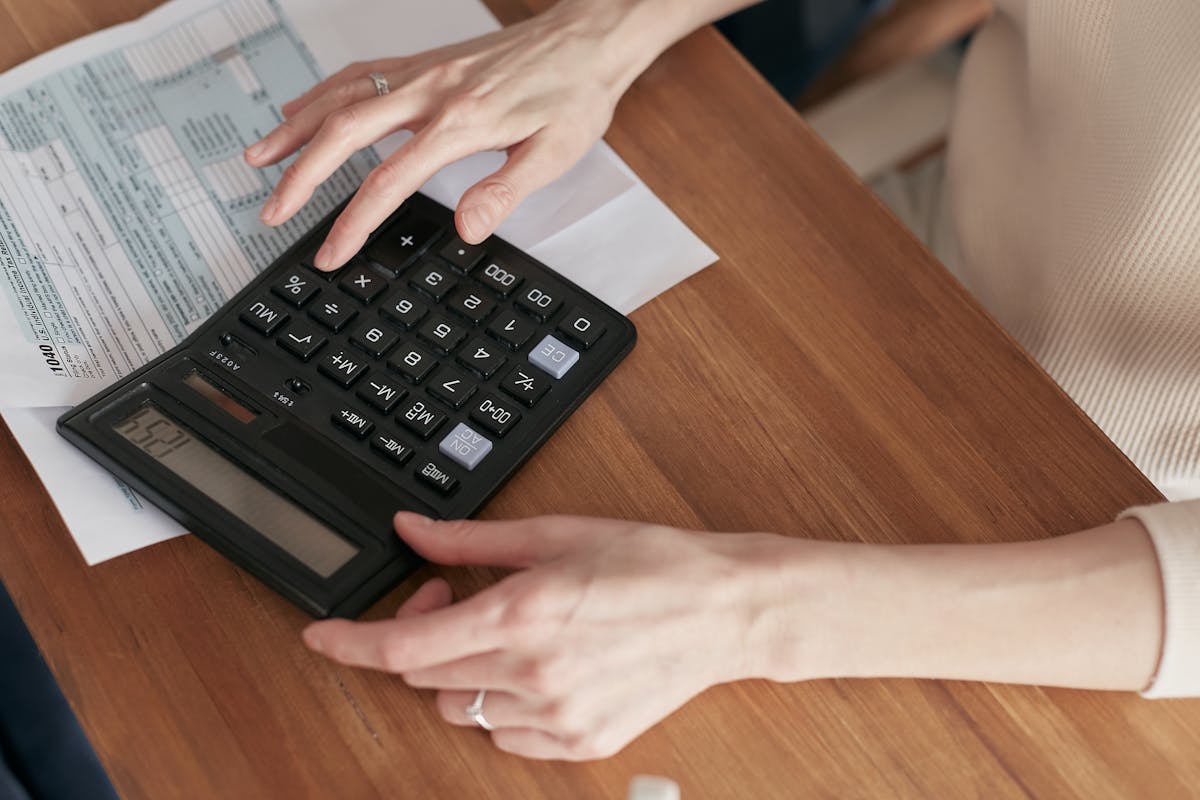 Close-up of a woman using a calculator and reviewing bills