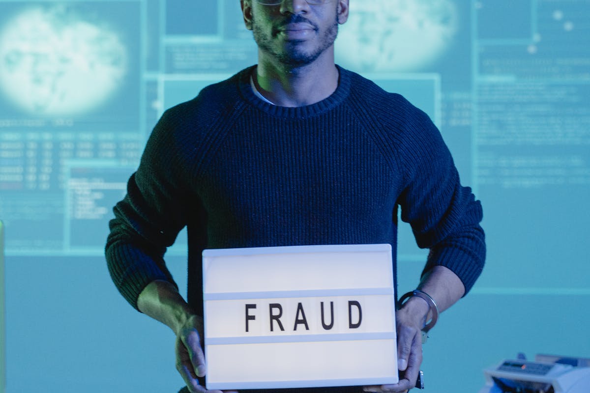 Man Holding a Sign that Says Fraud