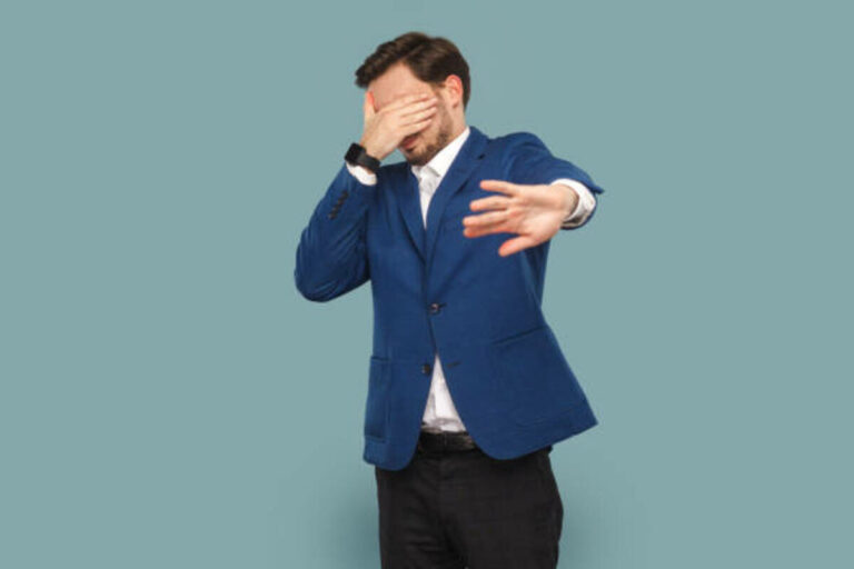 Man With Mustache Standing And Covering Eyes With Palm