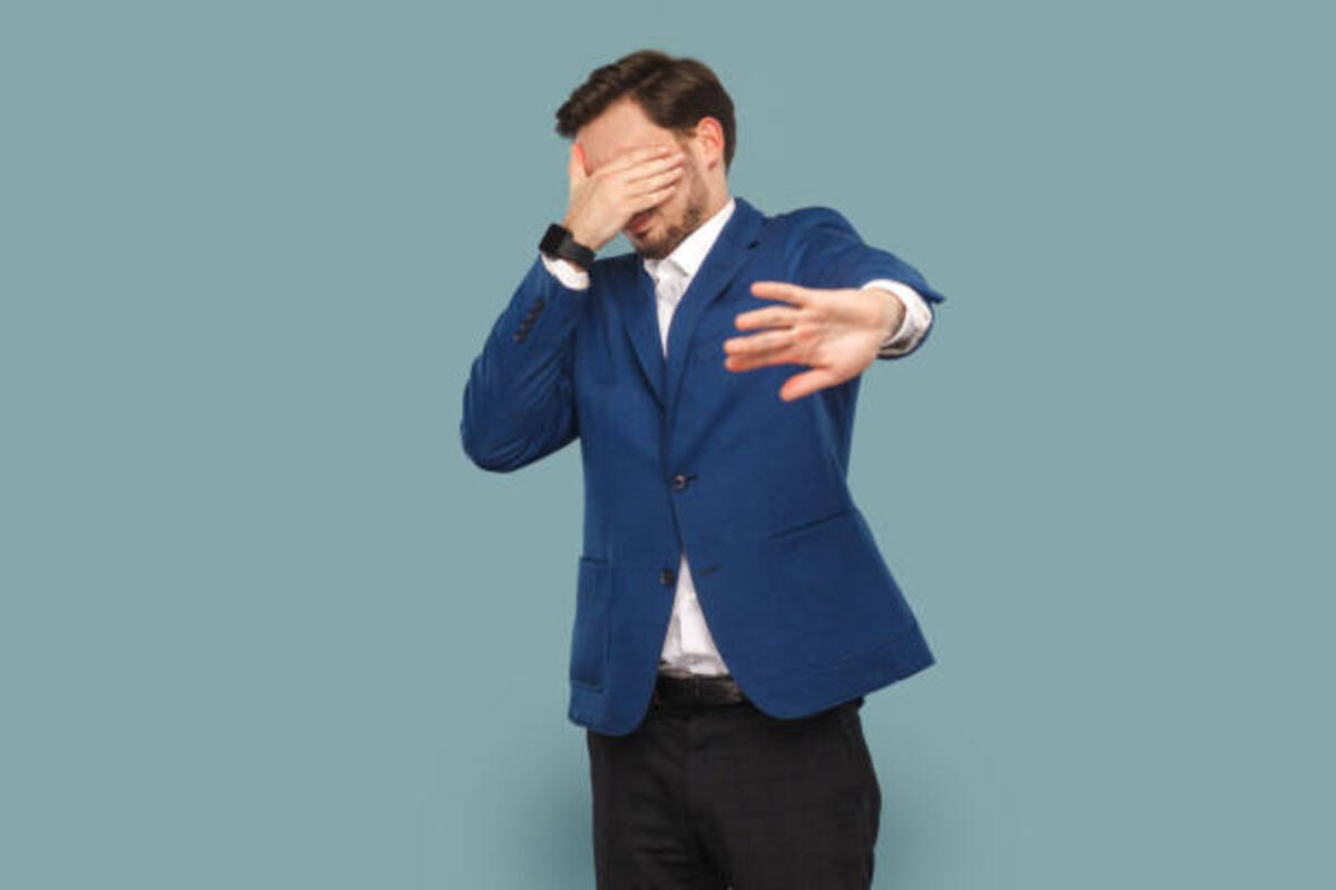 Man With Mustache Standing And Covering Eyes With Palm