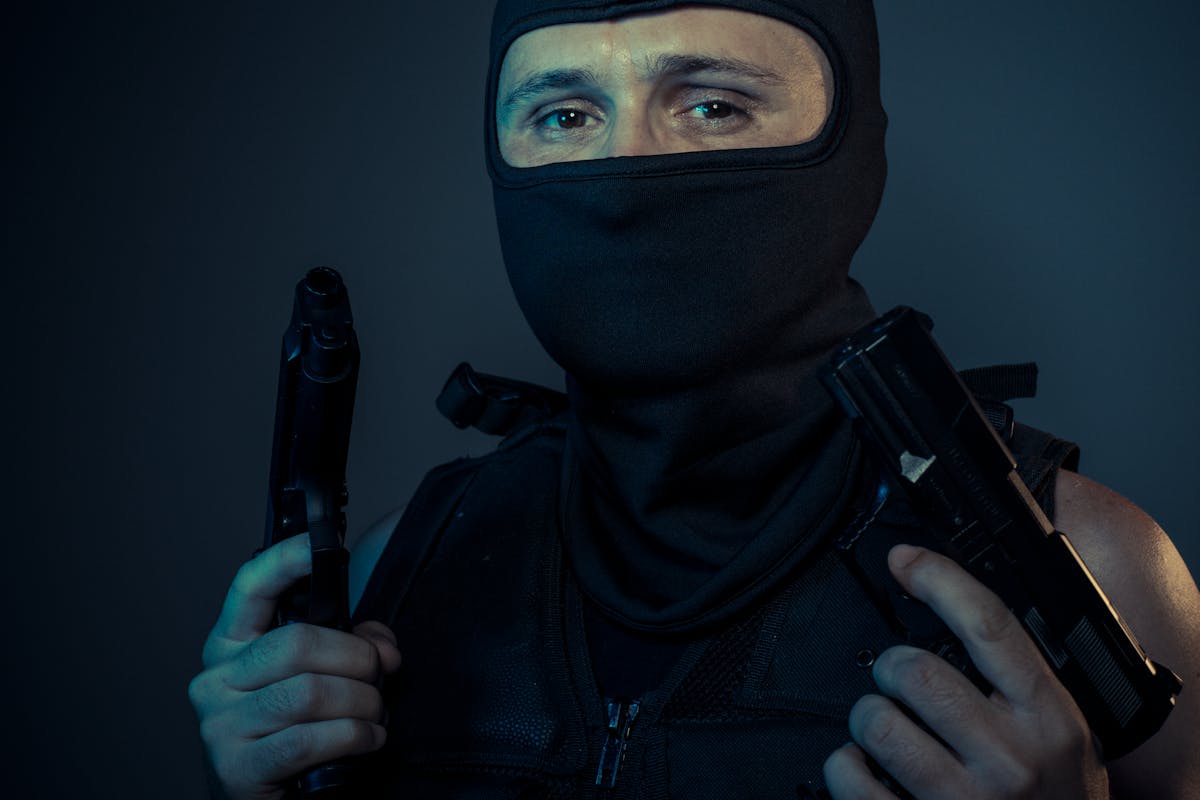 Man in Mask Holding Guns