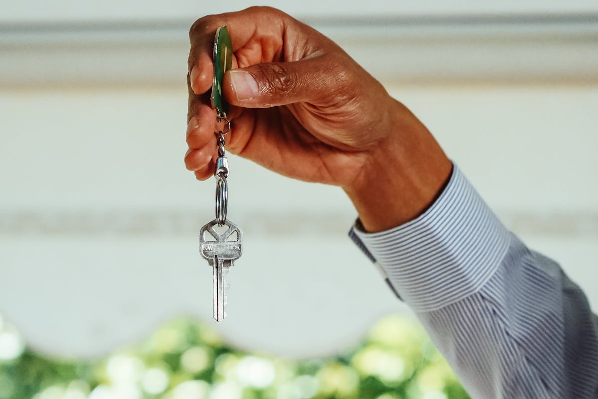 Person Holding Silver Key With Clear Gemstone