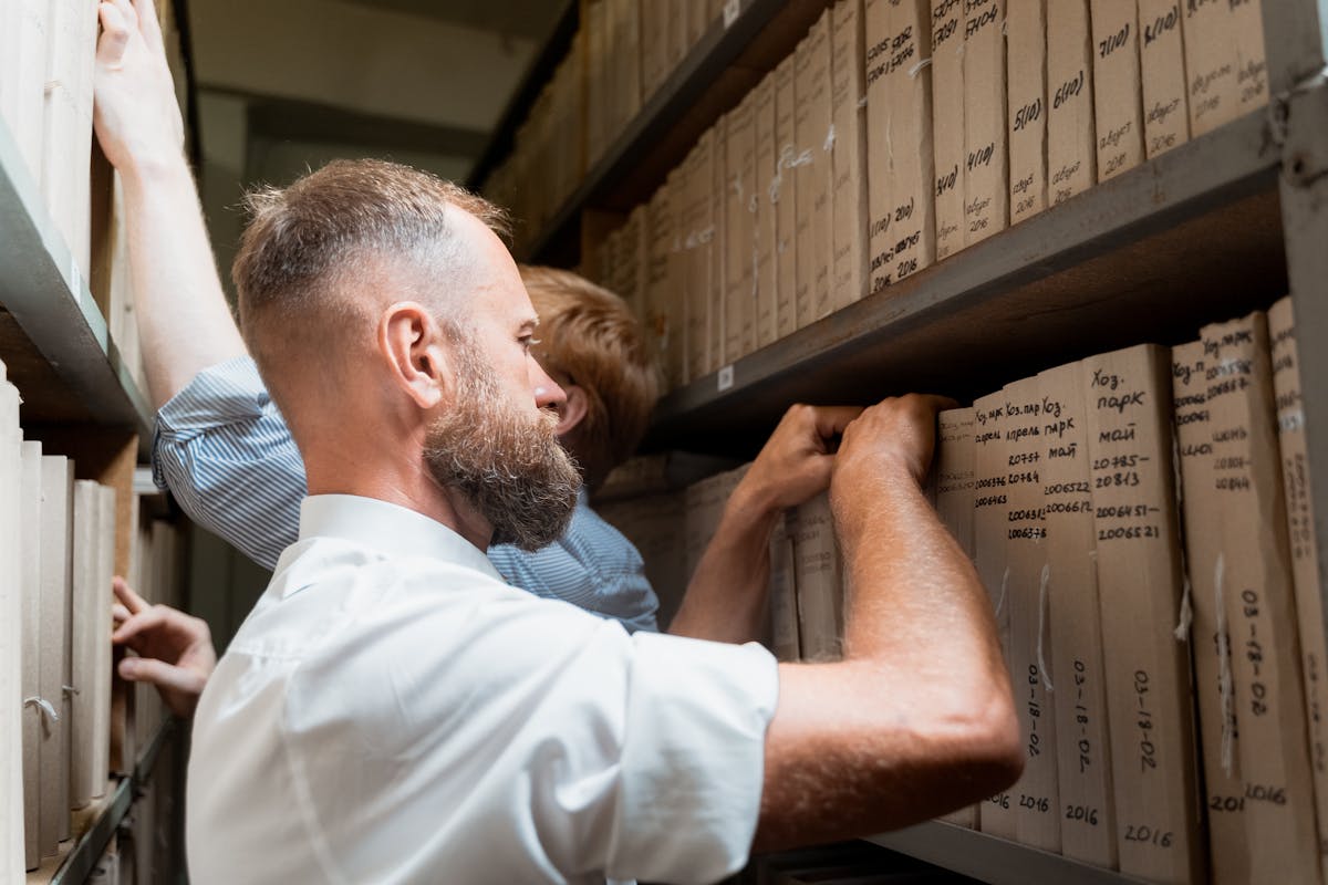 Two men organizing paperwork in an archive