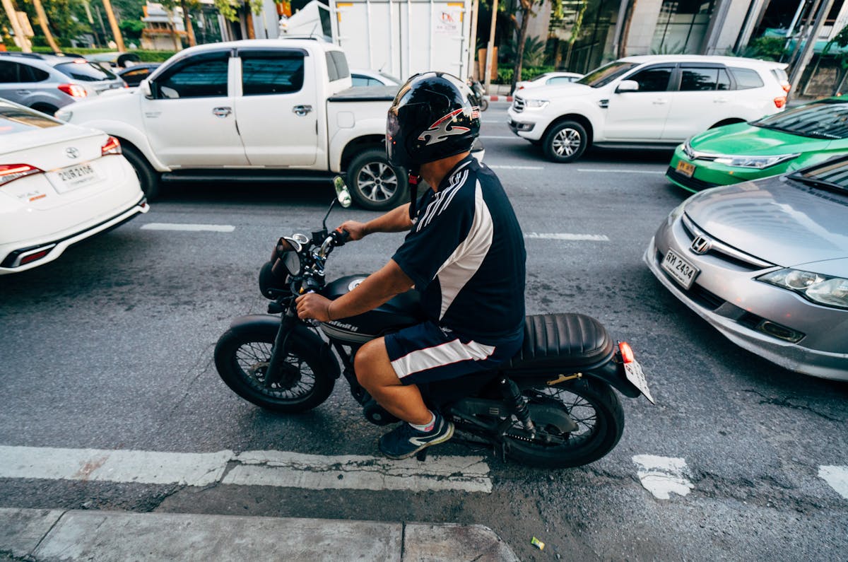 Man Riding a Motorcycle Near Cars