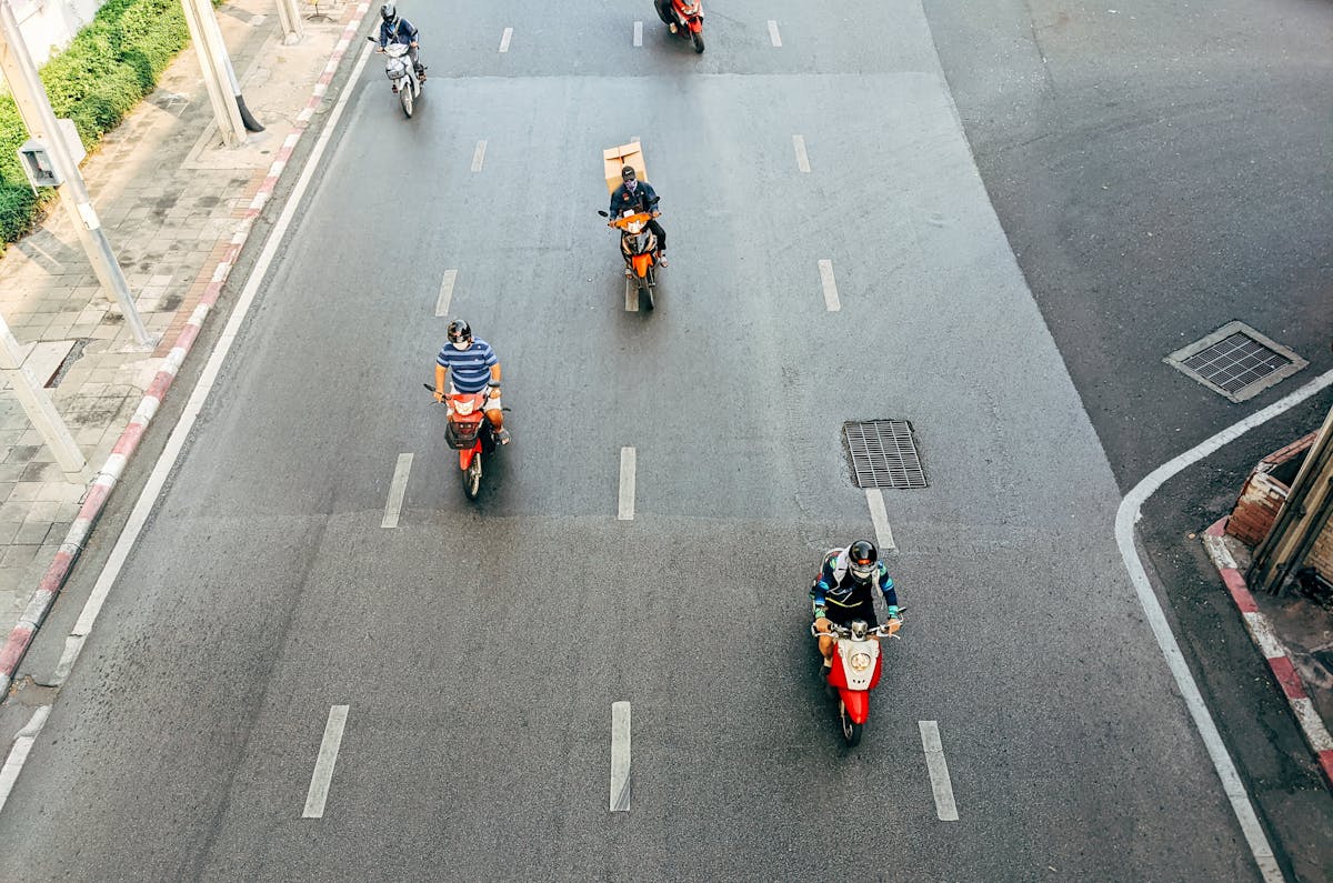 People Riding on Red and Black Sports Bike on Road